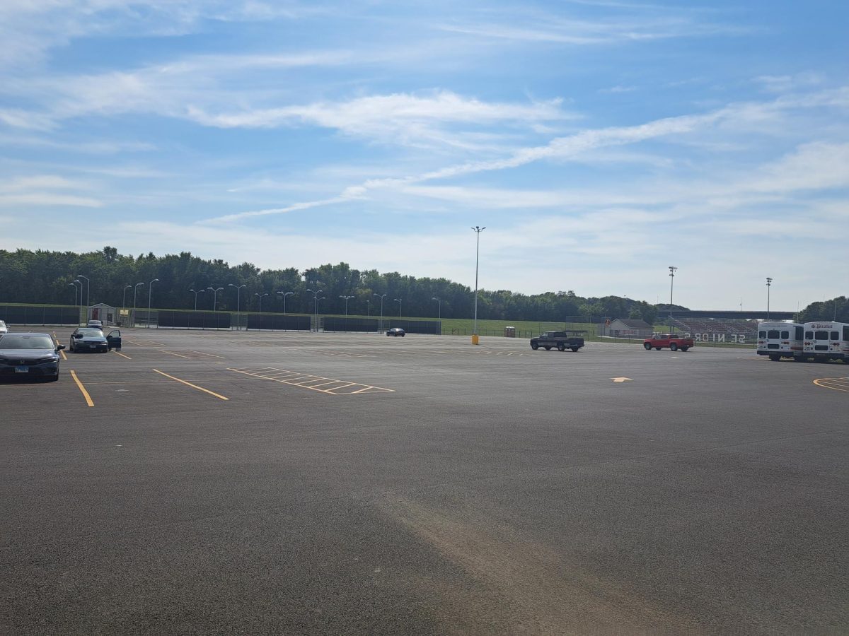 The parking lot sits finished with a couple of cars sitting in the sun.