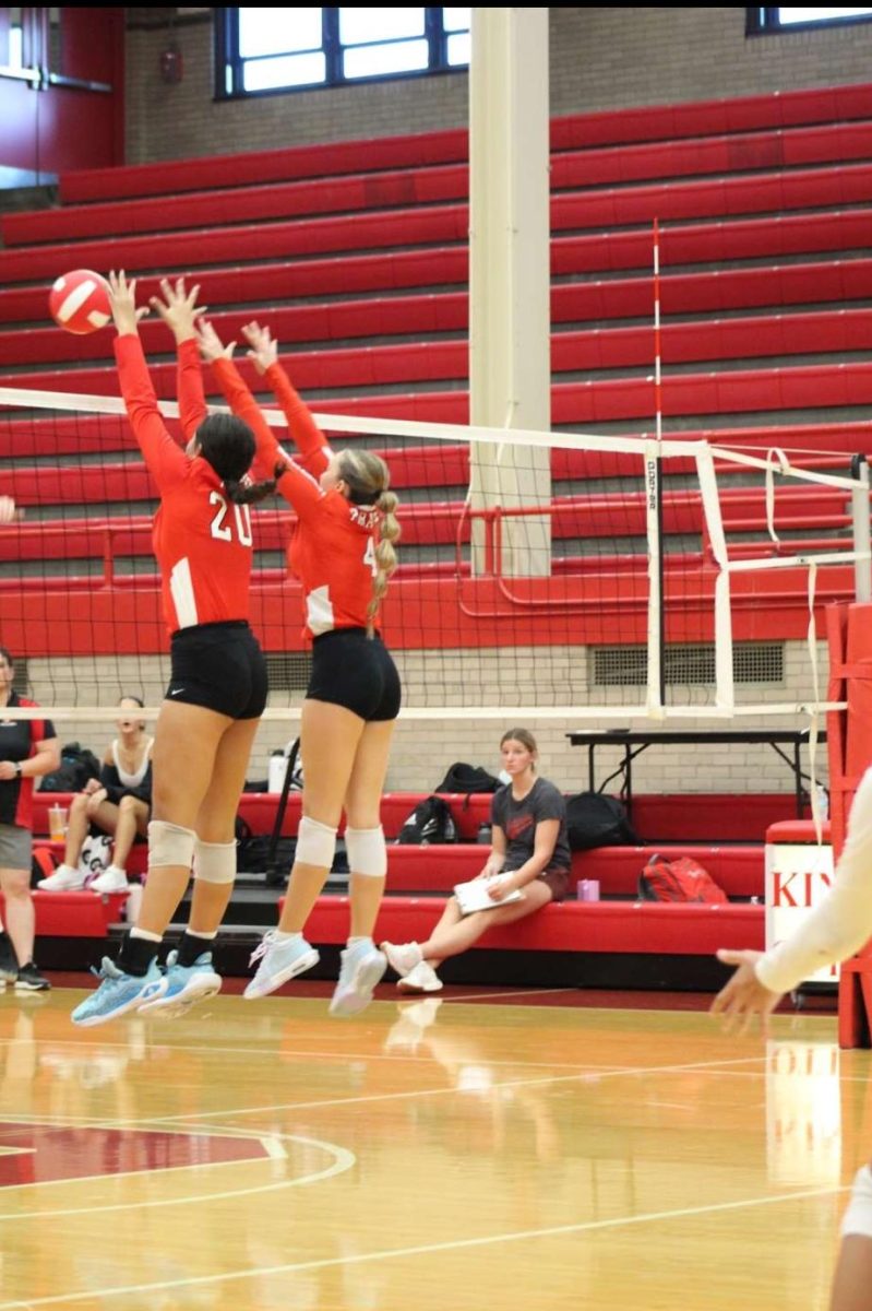 Wall of defense, Bella Knoll and Emily Snyder block their way to a victory. Knoll and Snyder are blocking against a big Kaneland hitter to get the win. In the past week in practice they have been working on blocking." After working hard all week getting that block felt amazing." Knoll said. 