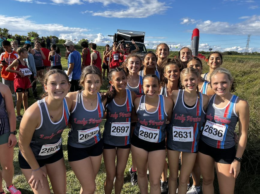 The varsity girls smile big at the camera before it's time to race.