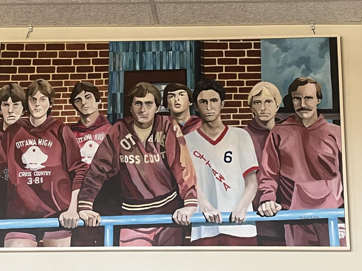 Former teacher Doug Hearn is featured in this painting that is located in the library classroom. This painting has former cross country team members and former teacher and coach, Paul Smith.  