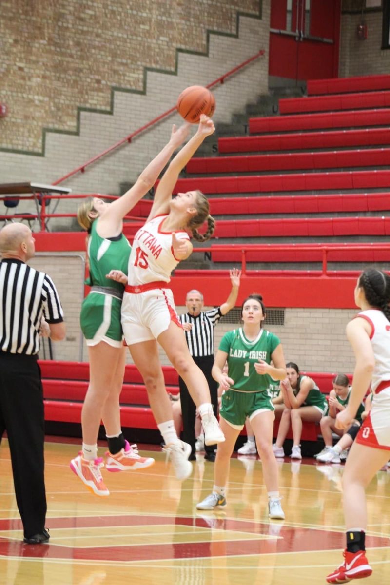 Springing up to start the game. Senior Hailey Larsen does jump ball for the varsity girls basketball team against Senica High School. The team won the game by thirty points: 55-25.