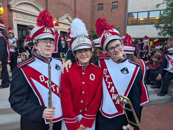(Left) senior Robert Murphy, (Middle) senior Bethany Polega, and (Right) freshman Christopher Polega all pose for a picture together in the school's courtyard before the football game 