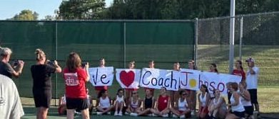 The girls tennis team takes part in showing their appreciation for Coach Steve Johnson on Senior night.