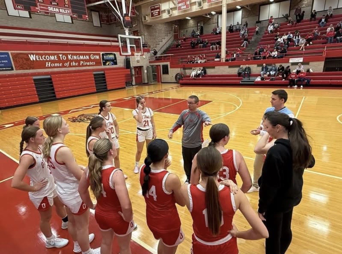 Head varsity girls’ basketball coach Brent Moore talks to the team in a huddle. He is getting them prepared for their Red and White night scrimmage. “Work together and play together. Be engaged with the scout. Have good spacing offensively and have fun. I say things like this to the girls before a game to help them stay mentally prepared but also remind them that basketball is supposed to be fun,” Moore said.