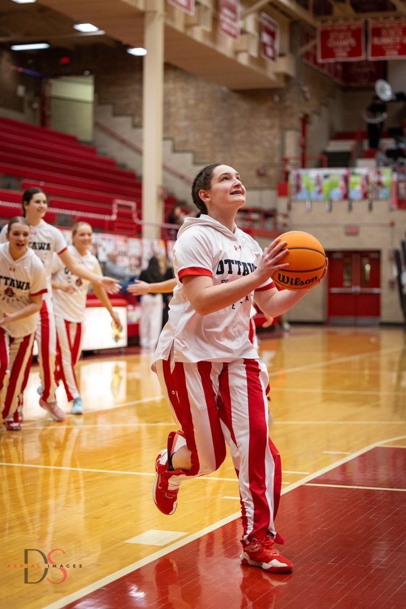 Greatness starts in warmups. Senior Mary Stisser goes for a layup during warmups. "Nothing compares to the energy of Kingman Gym when the team runs out for warmups," Stisser said. 