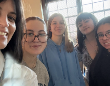 Teacher Ashley Carls smiling big while taking a selfie with seniors Madi Schmidt, Kaylee Santoy, Makenzie Blazys, and Hailey Abromaitis who are putting together and organizing the career fair as part of their curriculum for the semester with Carls. 