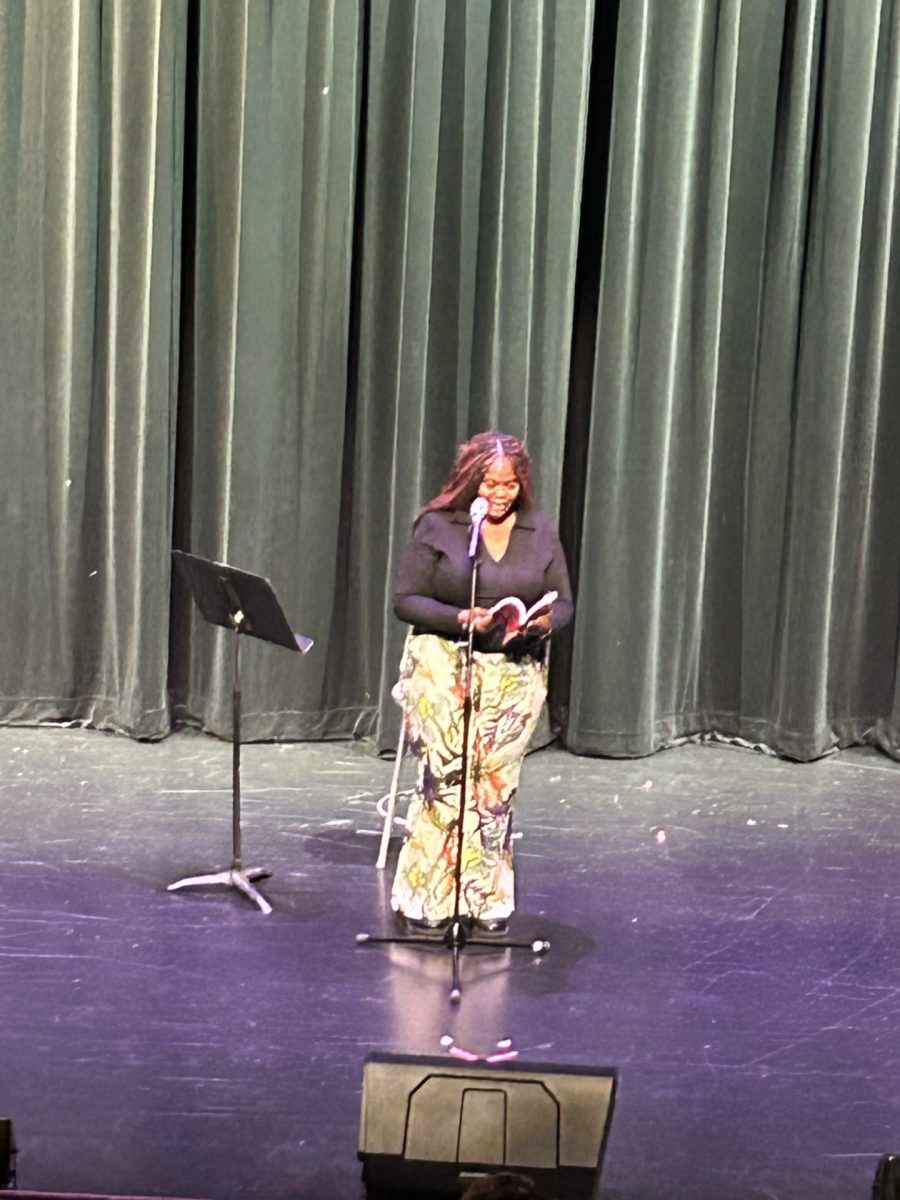 Ashlee Haze is reading one of her 	poems from her book at the 	second day of Fine Arts. 