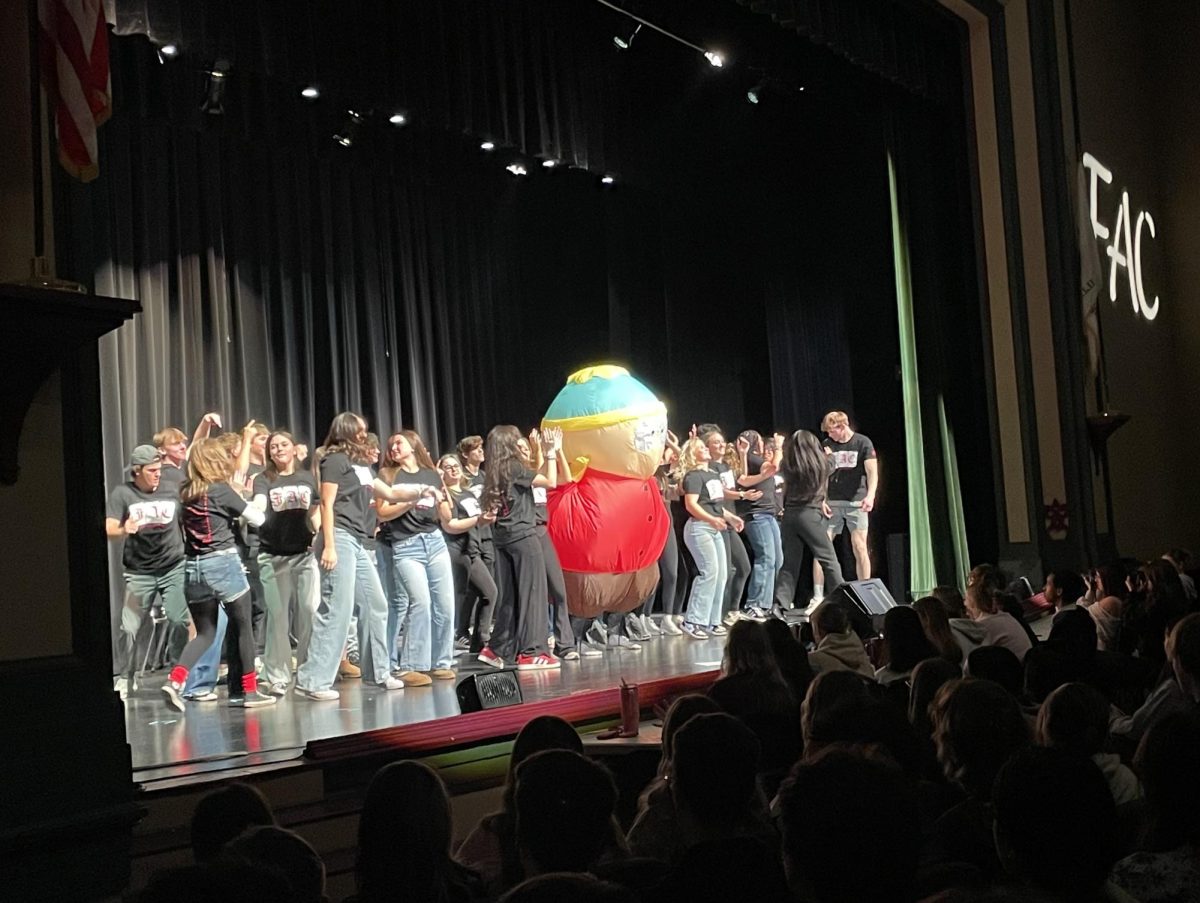The Fine Arts Club dances together on stage with cartoon character Eric Cartman to conclude Fine Arts Presents.